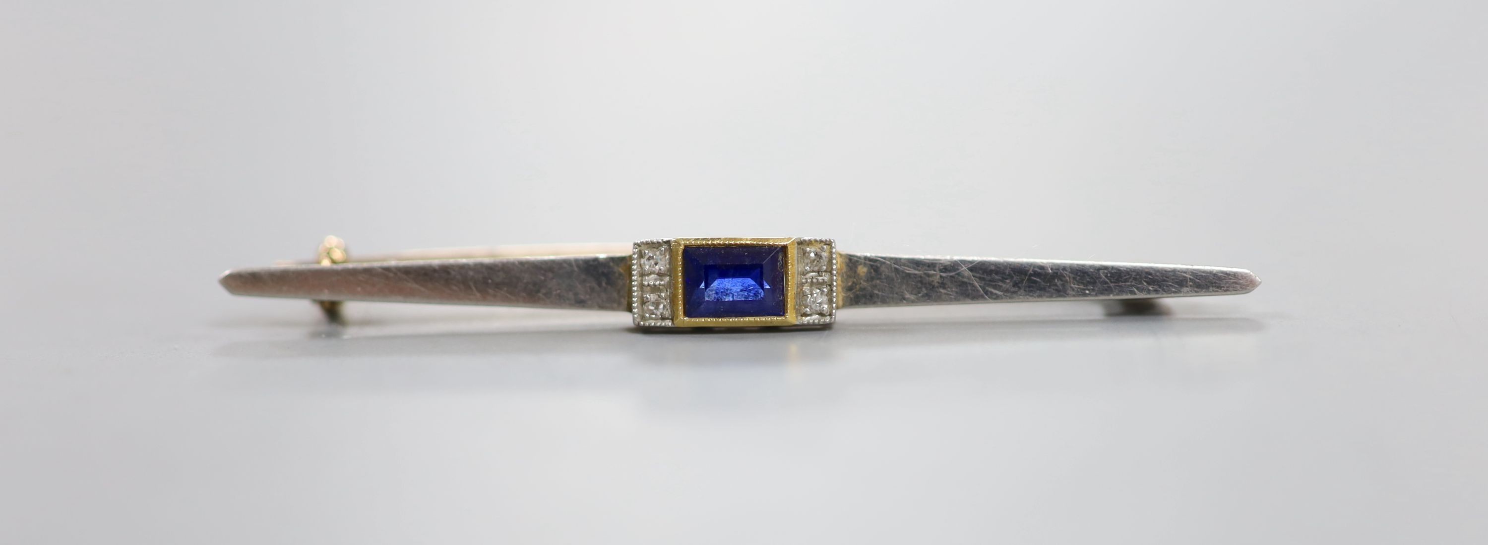 A 1930's/1940's yellow metal, synthetic sapphire and diamond chip set bar brooch, 55mm, gross weight 4.2 grams.